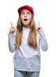 © Krakenimages.com - Young beautiful girl wearing red cap isolated background amazed and surprised looking up and pointing with fingers and raised arms.