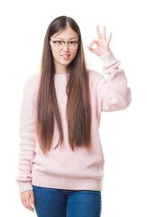 Sticker - Young Chinese woman over isolated background wearing glasses smiling positive doing ok sign with hand and fingers. Successful expression.