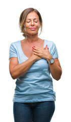 Wall Mural - Middle age senior hispanic woman over isolated background smiling with hands on chest with closed eyes and grateful gesture on face. Health concept.