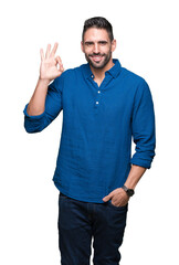 Canvas Print - Young handsome man over isolated background smiling positive doing ok sign with hand and fingers. Successful expression.