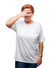 Canvas Print - Atrractive senior caucasian redhead woman over isolated background peeking in shock covering face and eyes with hand, looking through fingers with embarrassed expression.