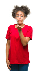 Poster - Young afro american woman over isolated background looking at the camera blowing a kiss with hand on air being lovely and sexy. Love expression.