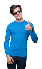 Sticker - Young man wearing funny thug life glasses over isolated background doing happy thumbs up gesture with hand. Approving expression looking at the camera with showing success.