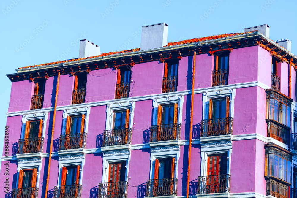 Pink building with balconies and windows. House painted in pink adding ...