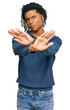 © Krakenimages.com - Young african american man wearing casual winter sweater rejection expression crossing arms doing negative sign, angry face