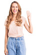 © Krakenimages.com - Young beautiful caucasian woman with blond hair wearing casual clothes showing and pointing up with fingers number four while smiling confident and happy.