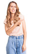 © Krakenimages.com - Young beautiful caucasian woman with blond hair wearing casual clothes pointing aside worried and nervous with forefinger, concerned and surprised expression