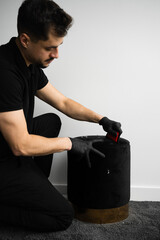 Wall Mural - Using the upholstery brush to dry clean furniture from dirt and pet footprints. Cleaner is removing dog hair from an ottoman chair with a fur brush.