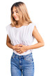 © Krakenimages.com - Beautiful caucasian woman with blonde hair wearing casual white tshirt with hand on stomach because indigestion, painful illness feeling unwell. ache concept.