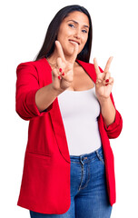 Wall Mural - Young beautiful brunette woman wearing elegant clothes smiling looking to the camera showing fingers doing victory sign. number two.