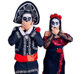 Poster - Young couple wearing mexican day of the dead costume over background shocked covering mouth with hands for mistake. secret concept.