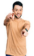 © Krakenimages.com - Hispanic man with beard wearing casual t shirt pointing to you and the camera with fingers, smiling positive and cheerful