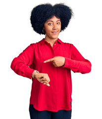 Canvas Print - Young african american girl wearing casual clothes in hurry pointing to watch time, impatience, upset and angry for deadline delay