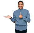 © Krakenimages.com - Young handsome hispanic man wearing casual sweatshirt showing palm hand and doing ok gesture with thumbs up, smiling happy and cheerful