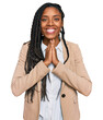 © Krakenimages.com - African american woman wearing business jacket praying with hands together asking for forgiveness smiling confident.