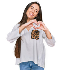 Poster - Young hispanic girl wearing casual clothes smiling in love doing heart symbol shape with hands. romantic concept.