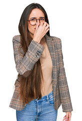 Canvas Print - Young hispanic girl wearing business clothes and glasses smelling something stinky and disgusting, intolerable smell, holding breath with fingers on nose. bad smell