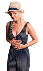 Sticker - Young beautiful blonde woman wearing summer hat and dress with hand on stomach because indigestion, painful illness feeling unwell. ache concept.