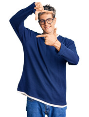 Wall Mural - Young handsome man wearing casual clothes and glasses smiling making frame with hands and fingers with happy face. creativity and photography concept.