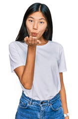 Sticker - Beautiful young asian woman wearing casual white t shirt looking at the camera blowing a kiss with hand on air being lovely and sexy. love expression.