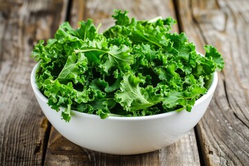 Kale salad served in white bowl on wood table