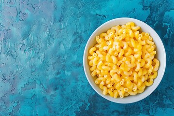 Canvas Print - Mac and cheese in white bowl on blue surface overhead shot