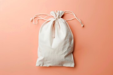 Sustainable cotton bag with white ties on peach backdrop