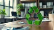 © Anna - Office environment with recycling symbol on desk, indicating eco-friendly and sustainable practices. Environmental awareness, corporate responsibility, green office, sustainable business.