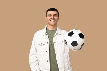 Poster - Handsome young man with soccer ball on brown background