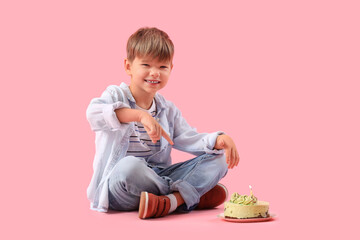 Poster - Cute little boy pointing at Birthday cake on pink background