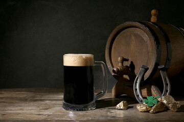 Wall Mural - Mug and barrel of dark beer, horseshoe and gold for St. Patrick's Day celebration on wooden table against black background