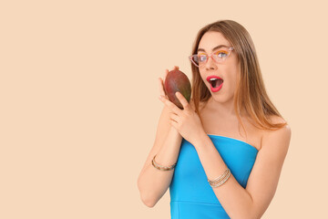 Poster - Shocked young woman with sweet mango fruit on beige background