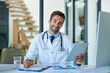 © SensSai/peopleimages.com - Hospital, online and portrait of doctor on tablet for consulting, medical service and telehealth. Healthcare, clinic and happy man on digital tech for website, research and documents for insurance