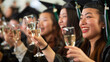 © EmmaStock - A group of women in graduation gowns are holding up their wine glasses