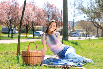 Poster - Beautiful young woman having picnic in park on sunny spring day