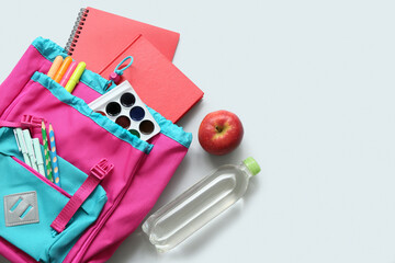 Wall Mural - School backpack with different stationery supplies, apple and bottle of water on white background