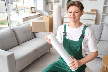 Wall Mural - Male worker with roll of stretch film in room