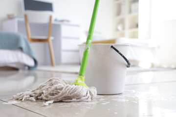 Canvas Print - Wet mop with bucket on floor in dorm room, closeup