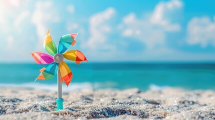 Close up of colorful toy windmill on sand with sea and sky background children s beach toy spinning in breeze summer seaside vacation scene