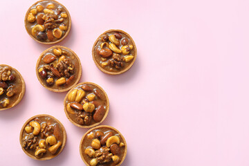 Canvas Print - tasty tarts with nuts and caramel on pink background