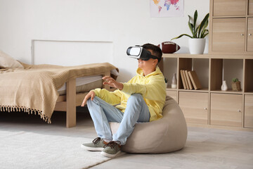 Canvas Print - Teenage boy using VR glasses in bedroom