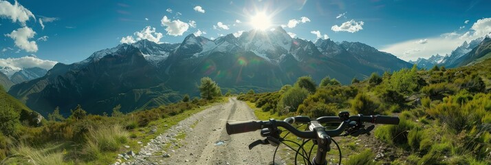 Wall Mural - Mountain landscape scenery features a black bicycle parked on the left side of the frame facing right towards majestic snow-capped peaks rising against a clear blue sky dotted with fluffy clouds.