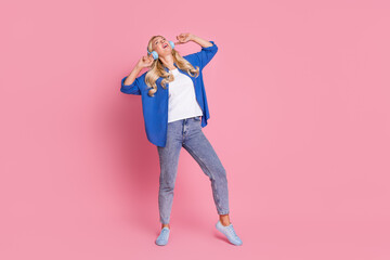 Poster - Full size photo of nice woman with wavy hair dressed blue shirt dancing in headphones enjoy pop playlist isolated on pink color background