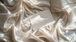 © ShStock - Blank paper card sheets with copy space on wrinkled bed blanket cloth with aesthetic warm sunlight shadows Flat lay top view