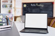 © Seventyfour - Background shot of laptop empty mockup screen on table in front of camera in primary school classroom, copy space
