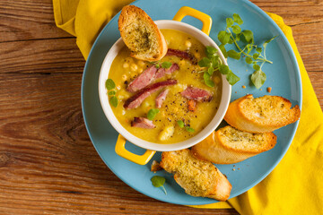 Wall Mural - Traditional Polish pea soup. Prepared with smoked meat. Served in a yellow bowl with croutons. Home made.