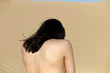 © Connect Images - A person stands with their back to the camera, overlooking a vast desert landscape with flowing sand dunes.