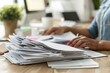 © Thanyaporn - HR specialist reviewing a stack of resumes at their desk, highlighting the meticulous process of candidate selection. The desk is organized with files, a computer, and office supplies, creating a