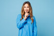 © ViDi Studio - Young fun woman she wear shirt casual clothes say hush be quiet with finger on lips shhh gesture looking camera isolated on plain pastel light blue cyan background studio portrait. Lifestyle concept.