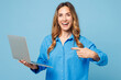 © ViDi Studio - Young smiling happy IT woman she wear shirt casual clothes hold use work point index finger on laptop pc computer isolated on plain pastel light blue cyan background studio portrait Lifestyle concept